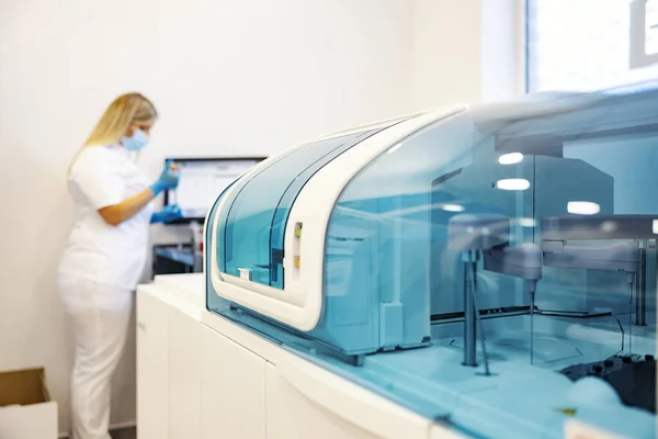 医学方面的技术和机械 实验室里的取样机在模糊的背景下是一名护士在做研究 — 图库照片