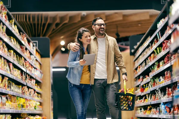 Sorridente Coppia Acquisto Generi Alimentari Dalla Lista Nel Supermercato — Foto Stock