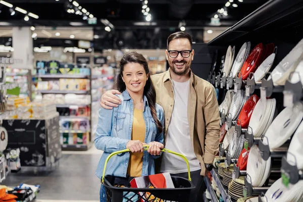 Una Feliz Pareja Abrazando Comprando Platos Para Hogar Supermercado Mientras —  Fotos de Stock