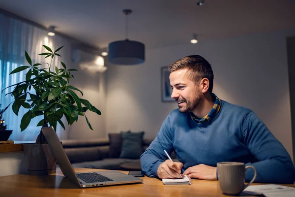 Homem Aprendendo Casa Sorrindo Para Laptop Escrevendo Notas — Fotografia de Stock