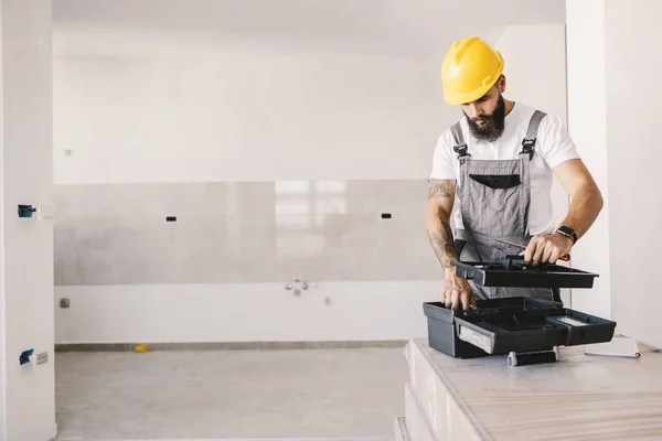 Een Arbeider Die Zijn Gereedschapskist Gebruikt Een Onafgewerkt Gebouw — Stockfoto