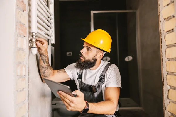 Een Werknemer Die Verwarmingsbuizen Controleert Een Gebouw Aanbouw — Stockfoto