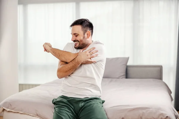 Egy Boldog Férfi Pizsamában Reggeli Gyakorlatokat Végez Kényelmes Hálószobájában — Stock Fotó