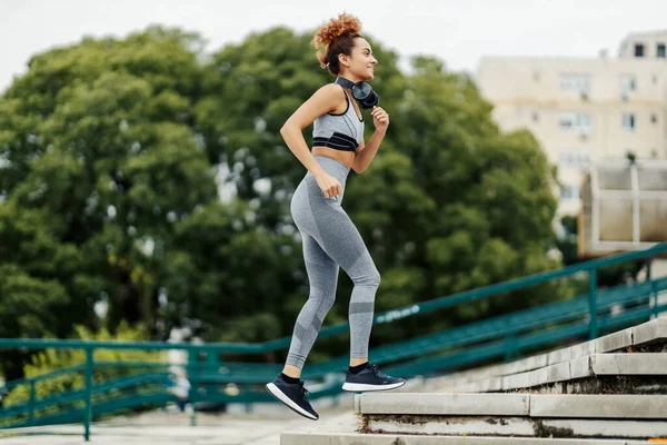 Šťastná Štíhlá Běžkyně Sluchátky Kolem Krku Běží Schodech Ven Sportovkyně — Stock fotografie