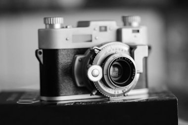 Siyah beyaz eski bir fotoğraf makinesi. Üzerinde lens olan bir kitap. Yakın çekim. Antika ekipman