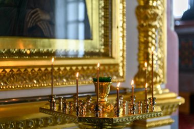 Rus Ortodoks katedralindeki ikonların arka planında kilise mumları