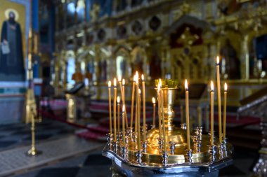 Rus Ortodoks katedralindeki ikonların arka planında kilise mumları