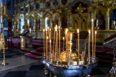 Rus Ortodoks katedralindeki ikonların arka planında kilise mumları