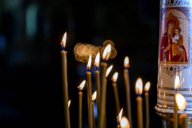 Rus Ortodoks katedralindeki ikonların arka planında kilise mumları