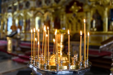 Rus Ortodoks katedralindeki ikonların arka planında kilise mumları