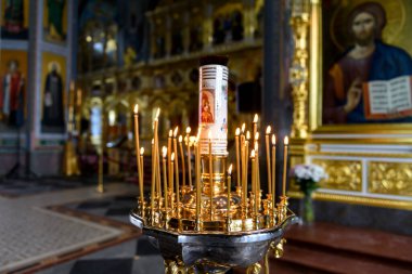 Rus Ortodoks katedralindeki ikonların arka planında kilise mumları
