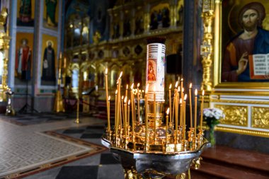 Rus Ortodoks katedralindeki ikonların arka planında kilise mumları