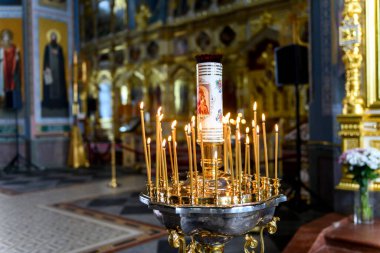 Rus Ortodoks katedralindeki ikonların arka planında kilise mumları