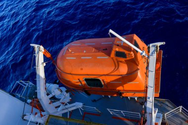 Turuncuyu tamamen kapalı bir filikayla suya indirmek. Tatbikatı terk edin. Filika eğitimi. Tatbikatta bir adam var..