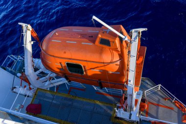 Turuncuyu tamamen kapalı bir filikayla suya indirmek. Tatbikatı terk edin. Filika eğitimi. Tatbikatta bir adam var..