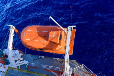 Turuncuyu tamamen kapalı bir filikayla suya indirmek. Tatbikatı terk edin. Filika eğitimi. Tatbikatta bir adam var..