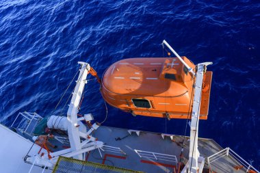 Turuncuyu tamamen kapalı bir filikayla suya indirmek. Tatbikatı terk edin. Filika eğitimi. Tatbikatta bir adam var..