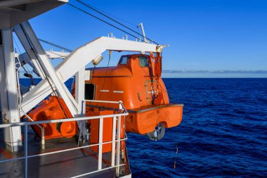 Turuncuyu tamamen kapalı bir filikayla suya indirmek. Tatbikatı terk edin. Filika eğitimi. Tatbikatta bir adam var..