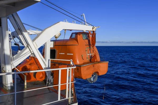 Turuncuyu tamamen kapalı bir filikayla suya indirmek. Tatbikatı terk edin. Filika eğitimi. Tatbikatta bir adam var..