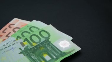 Makro bir sürü Avrupa faturası. Nakit para banknotları - finans ve yatırım konsepti - yakın çekim. 100 avroluk döviz kuru Avrupa 'nın zengin iş ekonomisi. Kamera masanın üzerinde gezer..