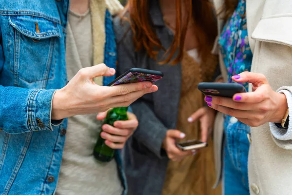 Genç insanlar akıllı telefon grubundan arkadaşlarıyla cep telefonu dijital dokunuşları ve teknoloji kavramları ile sohbet ederek mesajlarını iletiyorlar.