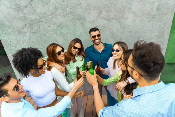 Jóvenes Amigos Felices Brindando Juntos Con Cerveza Botella Enfoque Tintineo —  Fotos de Stock