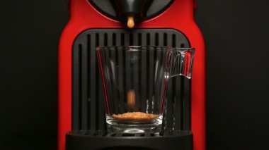 Kahve makinesiyle kahve makinesini cam şeffaf fincana çevirme süreci - otomatikleştirilmiş kahve makinesi makinesinden çıkan espresso kahve makinesi - siyah arka planda izole edilmiş. - Ağır çekimde..