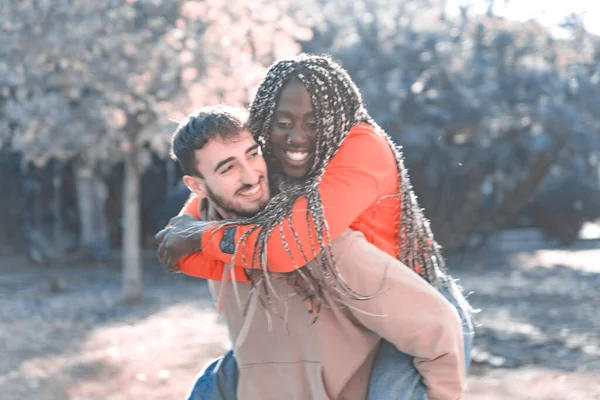 Sorridente Giovane Fidanzato Diversificato Che Trasporta Fidanzata Sulla Schiena Ride — Foto Stock