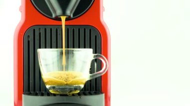 Kahve makinesiyle kahve makinesini şeffaf fincana çevirme süreci - kahve makinesi kapsülünden çıkan espresso kahvesi - beyaz arka planda.