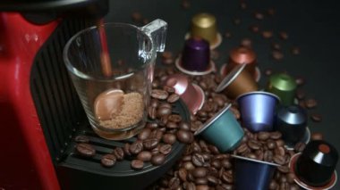 Kahve makinesiyle kahve makinesini cam şeffaf fincana çevirme işlemi - otomatikleştirilmiş kahve makinesinden çıkan espresso kahvesi - stüdyoda çok az izole edilmiş - siyah arka planda.