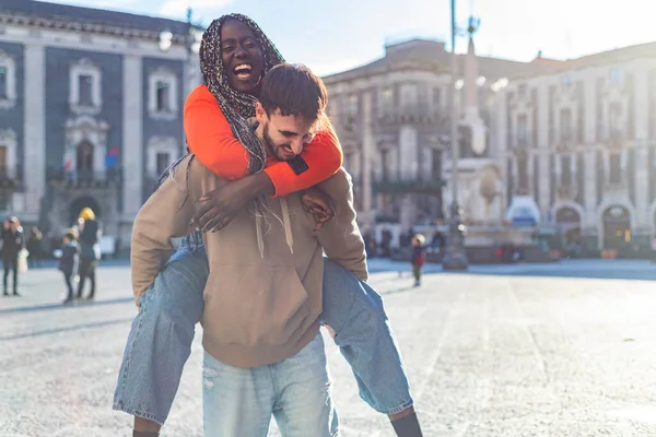 Sorridente Giovane Fidanzato Diversificato Che Trasporta Fidanzata Sulla Schiena Ride — Foto Stock