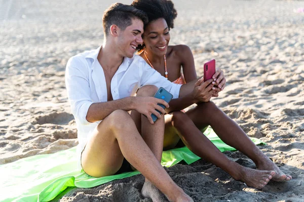 Smiling young couple using mobile phone  Happy young people looking smartphone  smiling woman and man  look cellphone 