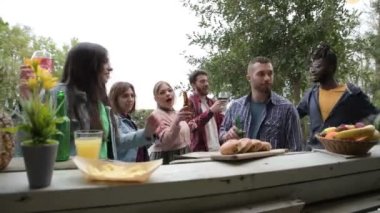 Multicultural group friends having fun at pool kiosk bar caf dancing  drinking cocktails and playing music with boombox player  home terrace party  multiracial young people dancing in pool terrace party 