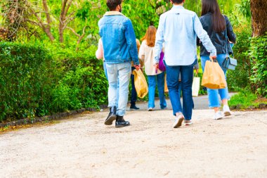Gençler ellerinde paketle geziyorlar, ellerinde yiyecek olan kağıt torbalarla, teslimat konsepti..