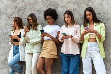 Genç güzel kadınlar cep telefonu kullanıyor. Akıllı telefonları olan gülümseyen kızlar. Mutlu cep telefonları.