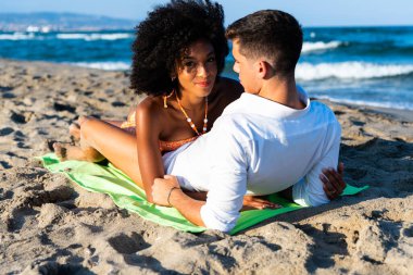 Sahilde kucaklaşan çok kültürlü romantik bir çift plaj geçmişinde çılgınca eğleniyorlar. Romantik genç çiftlerin yakın çekimi açık havada öpüşüp eğleniyorlar.