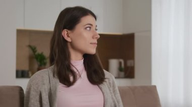 Yan bakan beyaz bir kadının portresi, kameraya dönüyor ve kameraya doğru bakarken gülümsüyor.