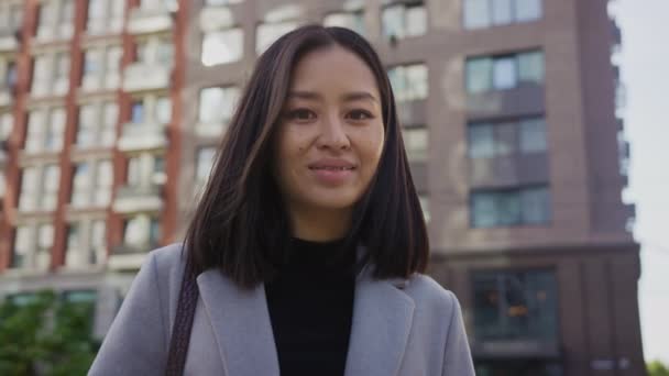 Retrato de una estudiante asiática de 20 años sonriendo con frenillos en la ciudad — Vídeo de stock