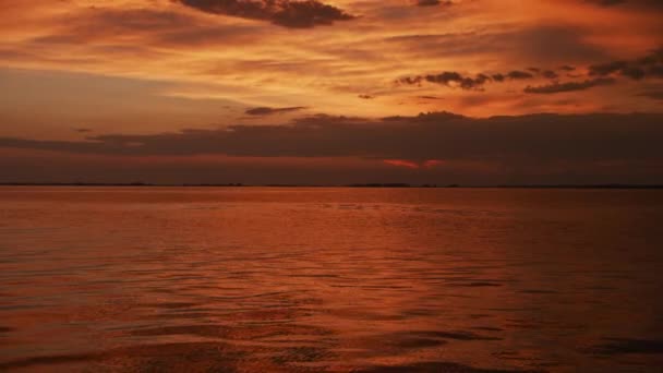 Wolny zoom optyczny na czerwonym zachodzie słońca nad rzeką latem — Wideo stockowe
