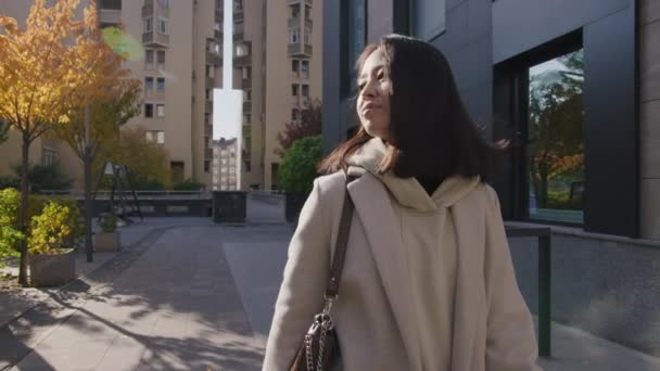 Mladý dospělý asijské businesswoman walking on a golden sunny autumn day in the city — Stock video