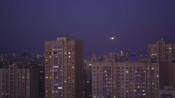 Avión de pasajeros volando a baja altitud sobre un suburbio de la ciudad mientras se aproxima al aeropuerto al atardecer — Vídeos de Stock