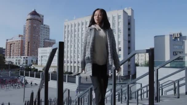 Paseo seguro de una joven mujer asiática adulta en el centro de la ciudad — Vídeos de Stock