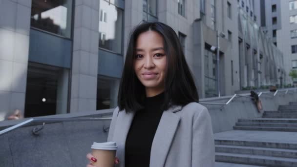 Портрет молодої дорослої 20-х азіатки-підприємниці, дивлячись на камеру в центрі міста — стокове відео