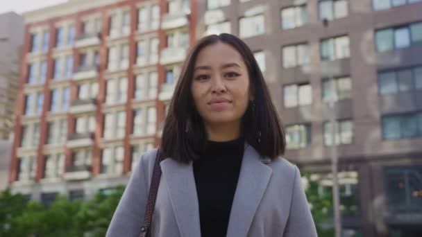 Zelfverzekerde blik van een jonge volwassen aziatische vrouw op een straat in het centrum — Stockvideo