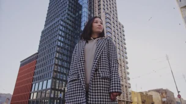 Baixo ângulo retrato de um jovem adulto asiático mulher no centro da cidade distrito — Vídeo de Stock