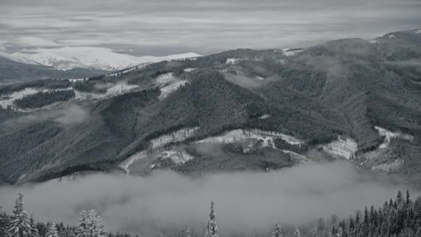 Långsam optisk zooma ut från en dimmig snöig utsikt över bergen — Stockvideo