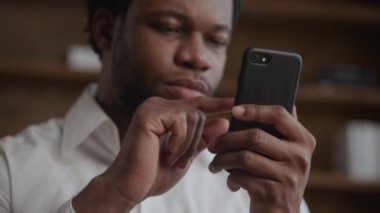 Genç, Afro-Amerikan bir adamın elindeki akıllı telefonu kapat.