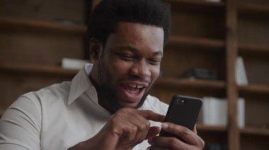 Heyecanlı bir adamın akıllı telefonuyla internetten alışveriş yapmasını kapat.