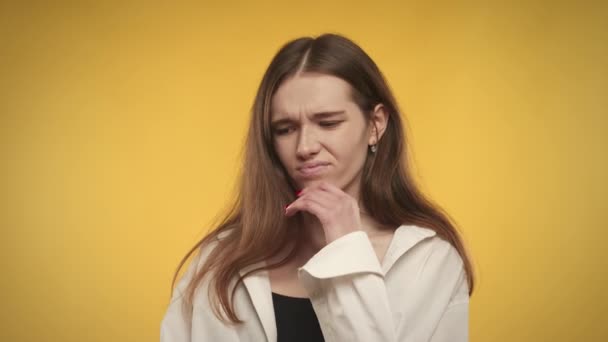 Joven mujer caucásica adulta se siente ansiosa sobre un fondo amarillo brillante en el estudio — Vídeo de stock