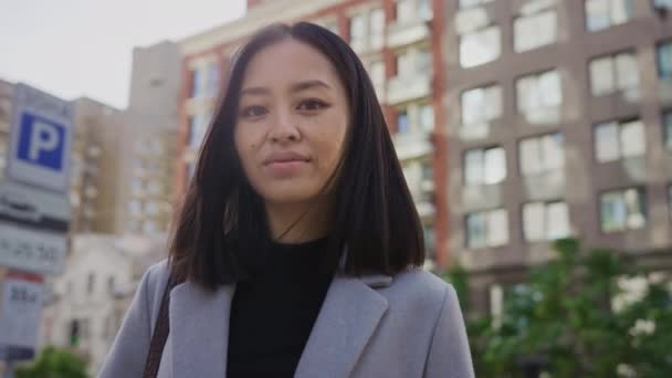 Portret dwudziestolatki azjatki studentki uśmiechającej się w centrum miasta — Wideo stockowe